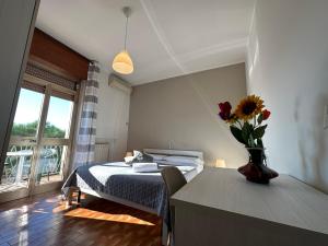 een slaapkamer met een bed en een vaas met bloemen op een tafel bij Hotel Miura in Cavalcaselle +20 foto's