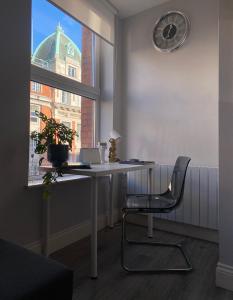 - un bureau avec un ordinateur portable et une chaise devant une fenêtre dans l'établissement Cosy and central Abbey Street Apt, à Dublin