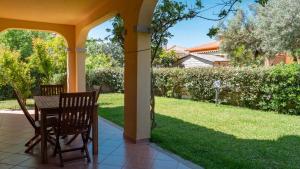 聖特奧多羅的住宿－Casa Vacanza la Suaredda，一个带桌椅的门廊和一个院子