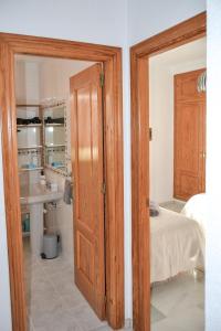 a bedroom with a bed and a bathroom with a sink at Casa típica y terraza, maison andalouse, typical house with rooftop in Almuñécar