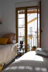 een slaapkamer met 2 bedden en een groot raam bij Casa típica y terraza, maison andalouse, typical house with rooftop in Almuñécar