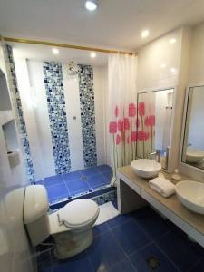 a bathroom with a toilet and two sinks and a shower at Apartamento Excalibur 11B junto al mar in Gaira