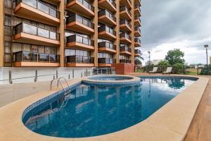 a swimming pool in front of a building at Flat Particular Hotel Kubitschek in Brasília