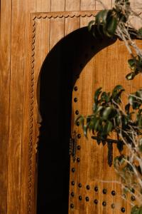 une porte en bois avec un miroir sur un mur en bois dans l'établissement Dar Tanja Boutique Hotel, à Tanger