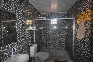 een badkamer met een douche, een toilet en een wastafel bij Casa de Praia in Coroa Vermelha