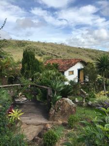 a small house in the middle of a field at Chalés Vista das Montanhas in Lavras Novas