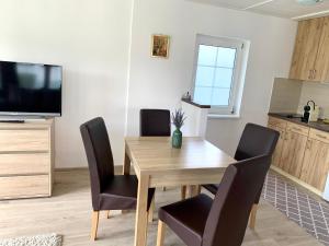 a dining room with a wooden table and chairs at Levendula Vendégház in Bük