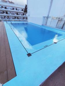 a large swimming pool with blue water in a building at Apartamentos Park Plaza in Puerto de la Cruz