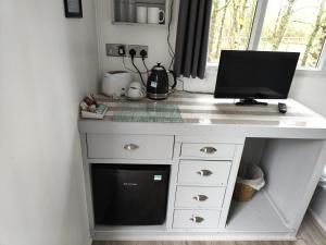 a white desk with a computer on top of it at Fairwood Lakes Holiday Park- Fishing Breaks - Woodland Huts in North Bradley