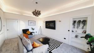 a living room with a couch and a chandelier at 69 St Georges Mansions in Glasgow