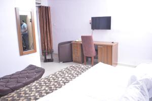 a bedroom with a bed and a desk and a mirror at Akure Airport Hotel in Oba Ile