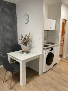 eine Küche mit einem weißen Tisch und einem weißen Herd mit Backofen in der Unterkunft Apartment 33 in Bad Hönningen