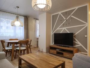 a living room with a television and a table at Kuuse 4 Apartment in Haapsalu