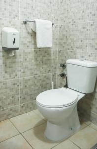 uma casa de banho com WC e toalhas na parede em Hotel Central Santa Maria em Santa Maria