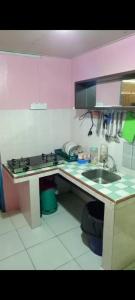 a kitchen with a sink and a stove and a counter at MAK Homstay Downstairs in Kundasang