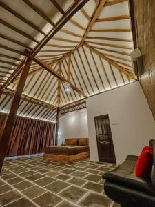 a living room with a couch in a room with a wooden ceiling at Villa Kamar Tamu Piyungan in Bantul