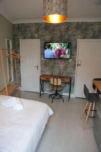 a bedroom with a bed and a tv on the wall at Cosy Chic Studio in King's Cross in London