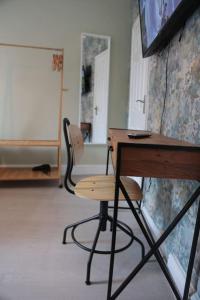 een klaslokaal met een bureau en een stoel en een tv bij Cosy Chic Studio in King's Cross in Londen