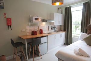 een kleine keuken met een tafel en een bed in een kamer bij Cosy Chic Studio in King's Cross in Londen
