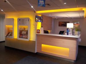 a bar in a restaurant with a counter and a refrigerator at ibis Budget Gennevilliers Asnieres in Gennevilliers
