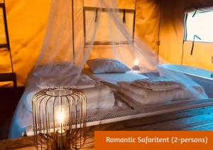 a bed in a tent with a cage at Safaritents & Glamping by Outdoors in Holten