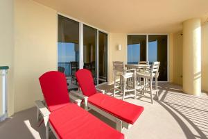 a patio with red chairs and a table on a balcony at Beach Colony East 15C-Penthouse in Perdido Key