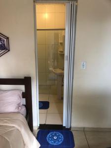 um quarto com um chuveiro e uma cama e uma casa de banho em Pousada Estação Lunar em São Domingos