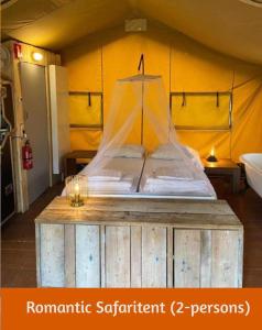 uma cama com uma rede num quarto em Safaritents & Glamping by Outdoors em Holten