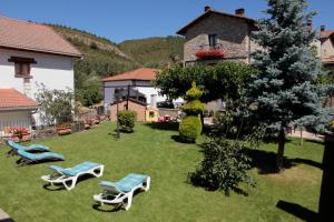 une cour avec deux chaises longues et une maison dans l'établissement Casa Rural Juliana, 