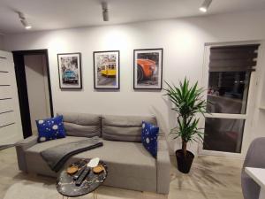 a living room with a couch and pictures on the wall at Nowoczesny apartament w sercu Wrocławia in Wrocław