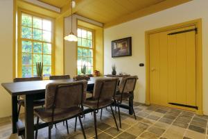 a dining room with a wooden table and chairs at Hoogheem Erfgoed & Logies in Nieuwolda +20 photos