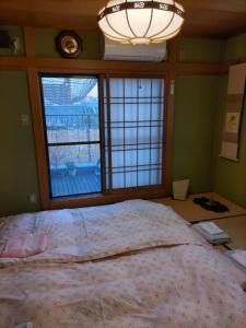 大阪的住宿－OTERA HOUSE 瑞　TAMA，一间卧室设有一张大床和一个窗户。