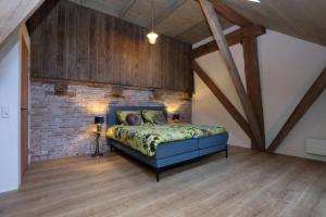 a bedroom with a bed and a brick wall at Hoogheem Erfgoed & Logies in Nieuwolda
