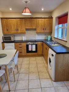 a kitchen with wooden cabinets and a dishwasher at Townhouse 2 Barrow Lane in Carlow