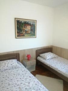 two beds in a room with a picture on the wall at Domaćinstvo Trifunović in Pretrešnja
