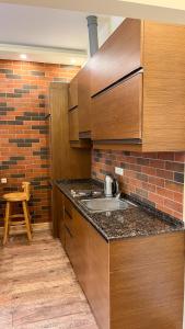a kitchen with a sink and a brick wall at Новая квартира у Площади in Yerevan