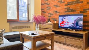 a living room with a tv and a table at Новая квартира у Площади in Yerevan