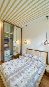 a large bed in a bedroom with two pendant lights at Новая квартира у Площади in Yerevan