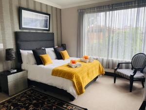 1 dormitorio con 1 cama con manta amarilla y ventana en Sunset Kloof, en Wilderness