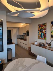 a living room with a ceiling fan and a kitchen at frontaal gelijkvloers seaview 80m² 2 slp in Ostend