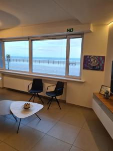 a living room with a view of the beach at frontaal gelijkvloers seaview 80m² 2 slp in Ostend