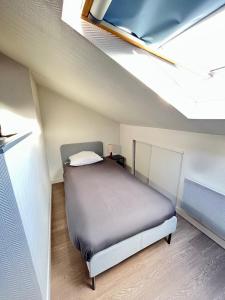 a small bedroom with a bed in a attic at Pin's - Magnifique appartement in Sarrebourg