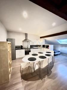 a large kitchen with a white table and chairs at Pin's - Magnifique appartement in Sarrebourg