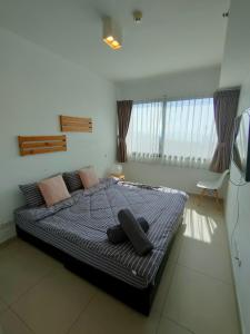 une chambre avec un grand lit avec des oreillers dessus dans l'établissement unixx seaview, à Pattaya (sud) 69 autres photos