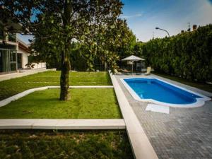 a swimming pool in a yard with a tree at Villa Magnolie in Corbetta