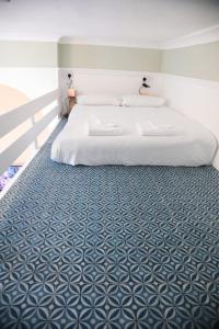 a bedroom with a bed with a blue and white floor at Sunlight Studio in King's Cross in London
