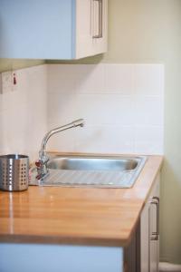 a kitchen counter with a stainless steel sink at Sunlight Studio in King's Cross in London