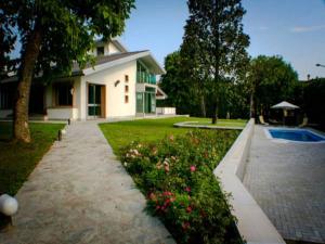 a house with a garden with flowers and a driveway at Villa Magnolie in Corbetta