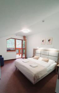 um quarto com uma cama grande e lençóis brancos em Holiday Family Raj Pod Sosnami em Szklarska Poręba
