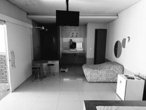 a black and white room with a bed and a kitchen at MOTEL HORA EXTRA in Jataí